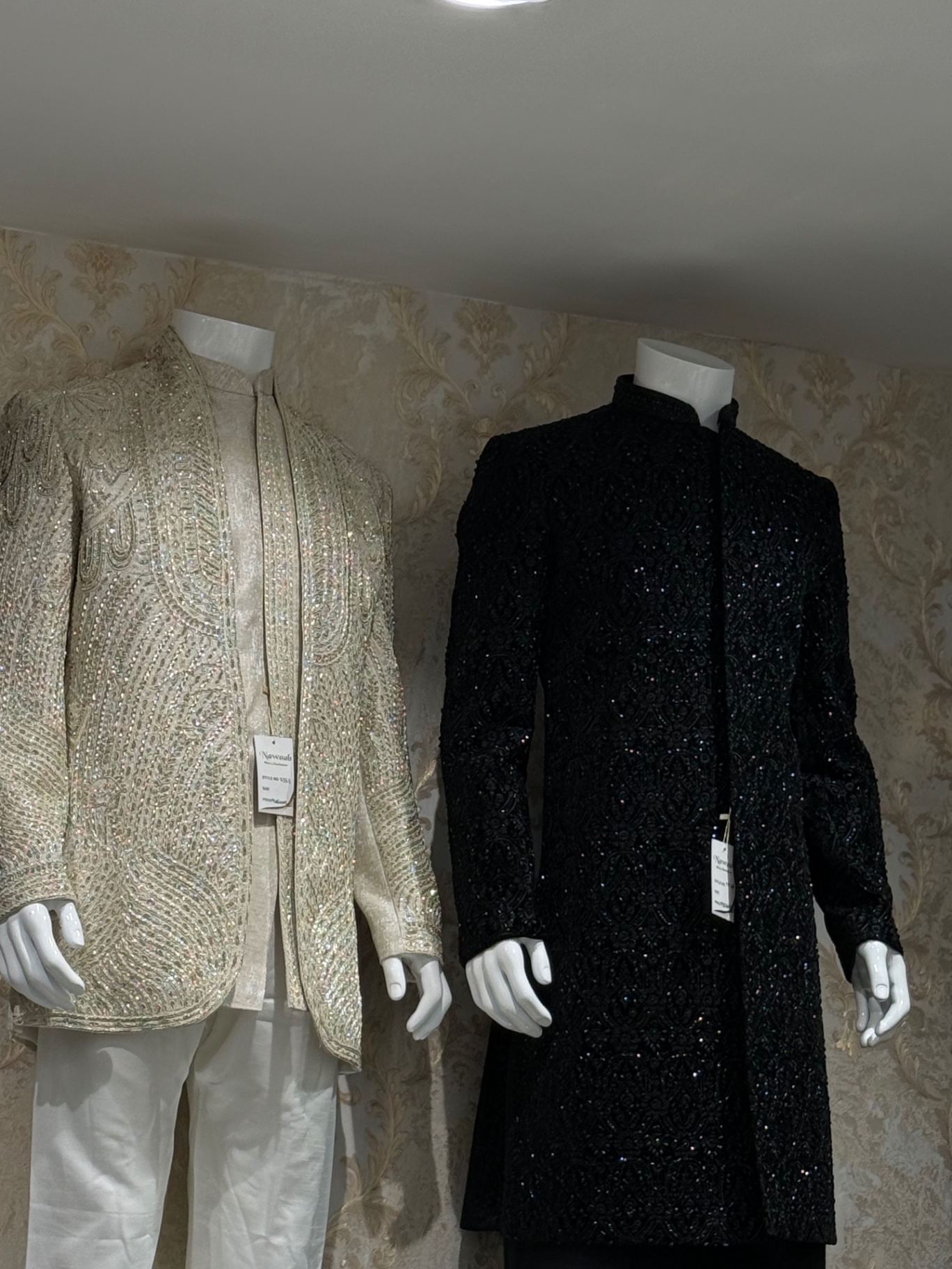 Ivory and black beaded sherwanis on mannequins